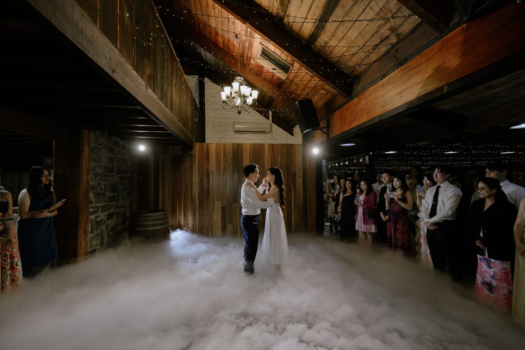 Romantic first dance of the newlyweds at Yarra Ranges Estate, lit by warm ambient lighting and surrounded by reception guests