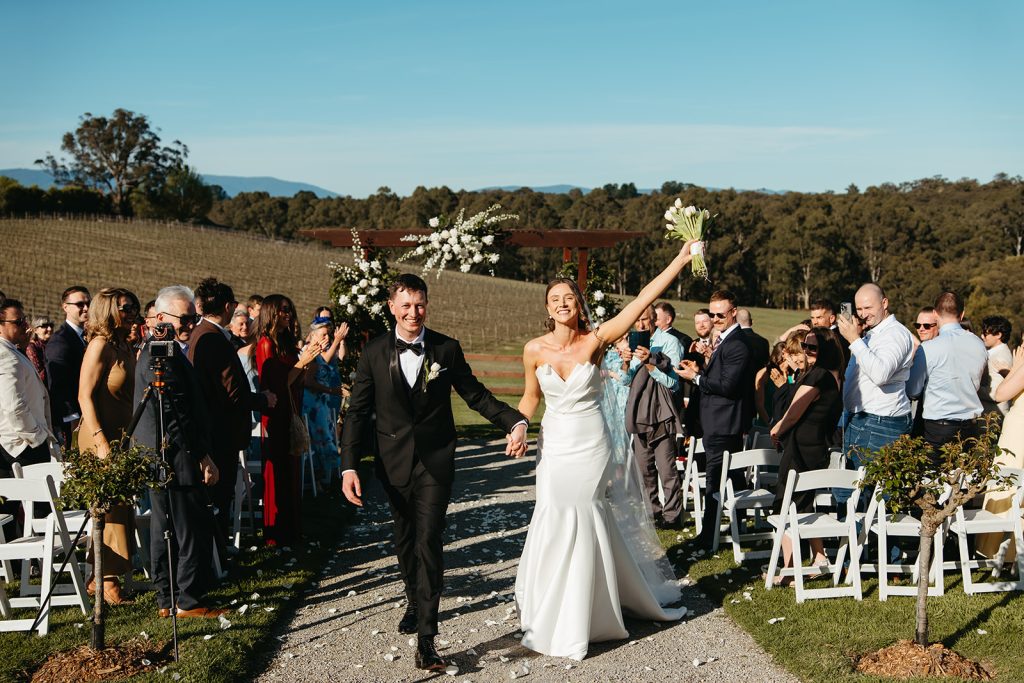 Beautifully styled ceremony setup at Yarra Ranges Estate featuring floral arbour and panoramic Yarra Valley scenery as Bride & Groom walk back up the aisle.